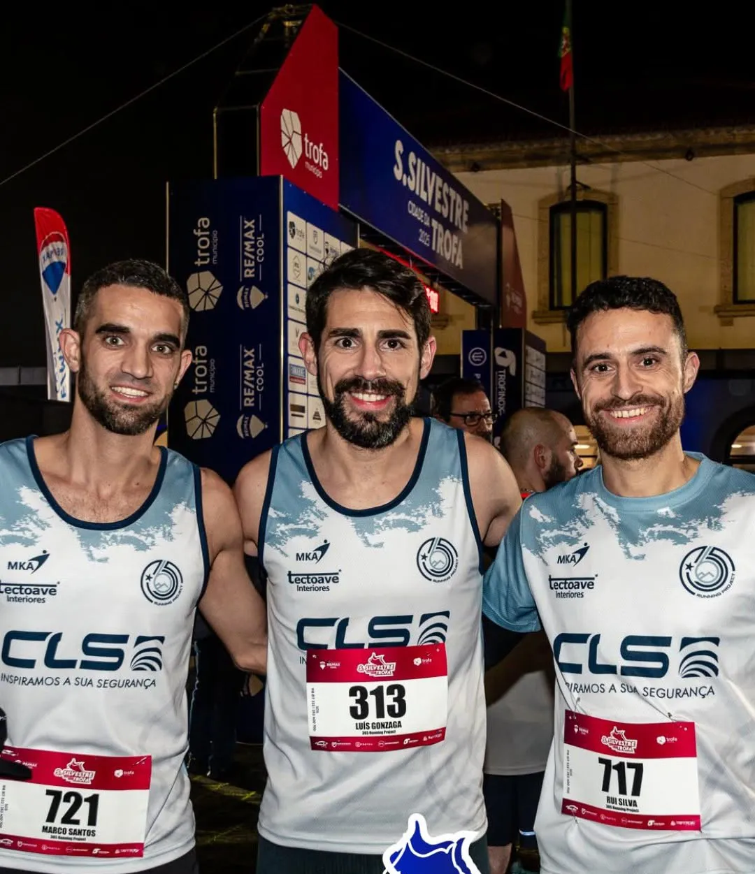 Três atletas do 365 Running Project sorriem com camisola CLS Brands após a corrida noturna.